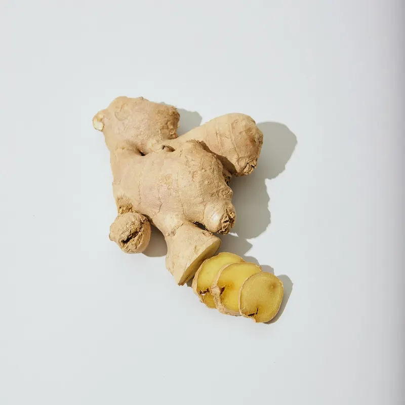 Verse gemberwortel (Zingiber officinale) op een lichte ondergrond